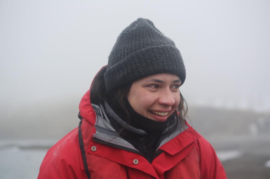 A woman, wearing a woolen hat and jacket, overcome with emotions.