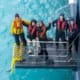 People smiling at the camera while standing on a boat gangway.
